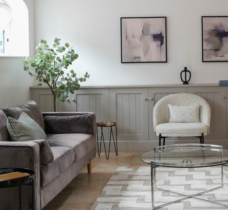 Decluttered living room corner with a cosy armchair, home organising and styling