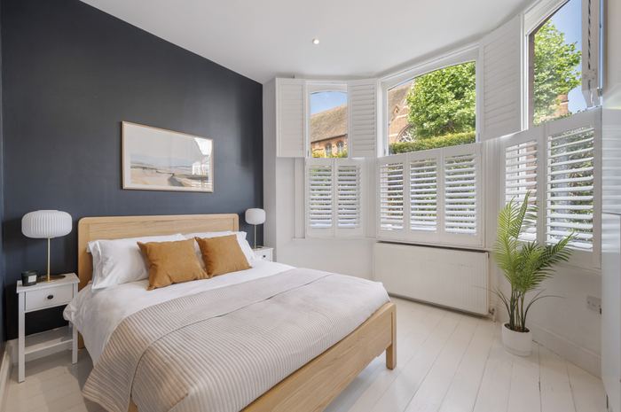 Bedroom after home staging with an oak bed and mustard cushions