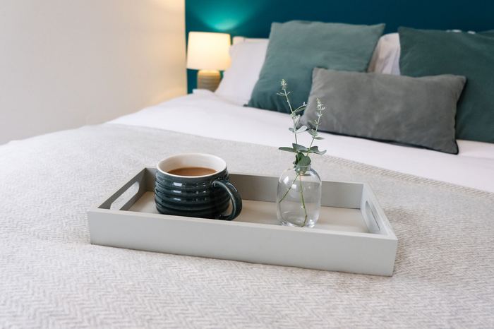 Breakfast tray detail with tea and a bud vase on the bed