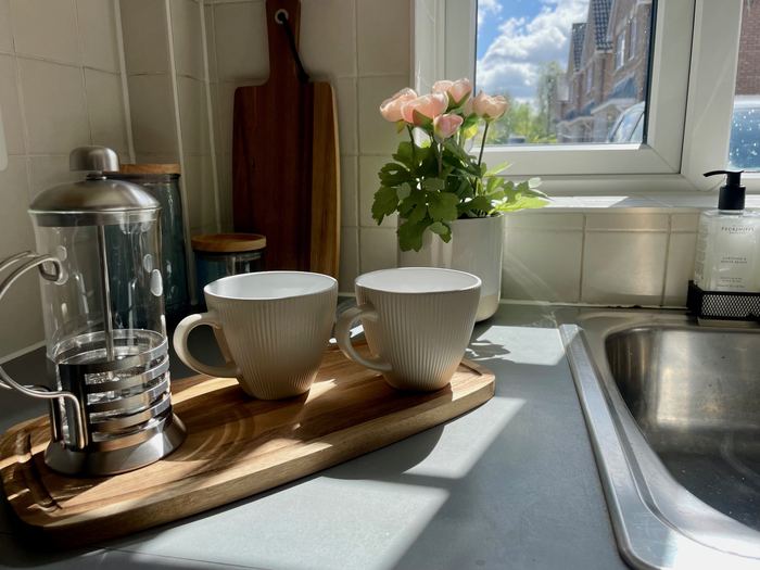 Kitchen counter decluttering detail with a coffee tray and fresh roses