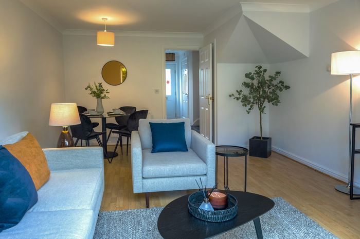 Living and dining room staged to sell with grey and blue seating