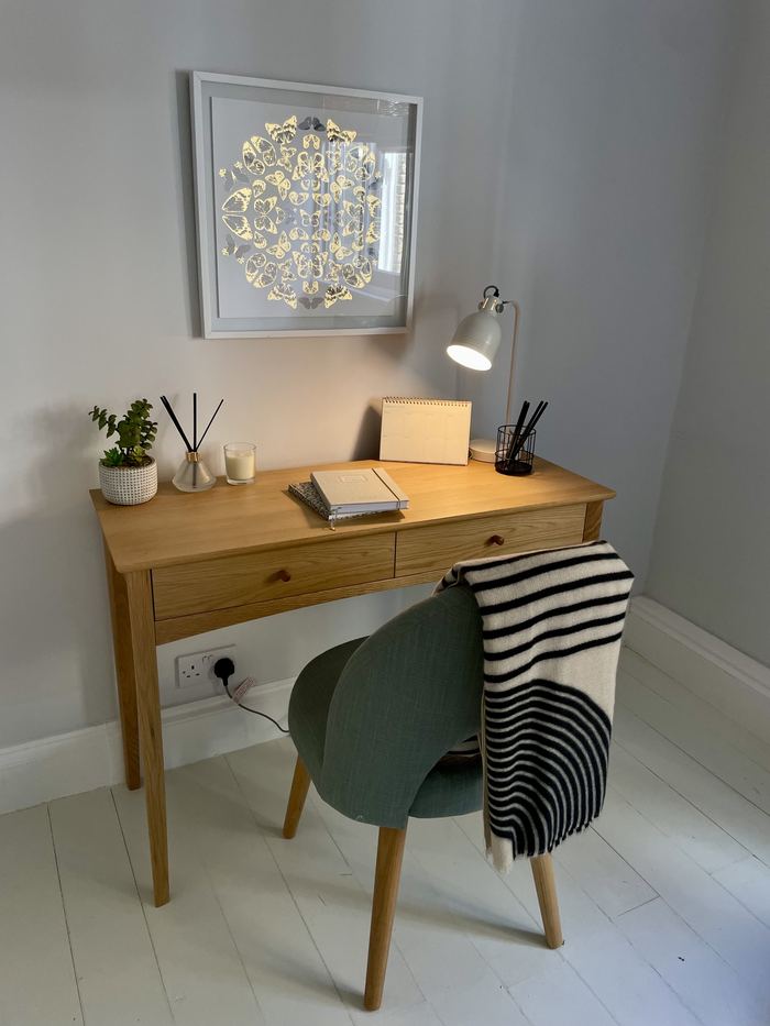 Home office corner styled and organised with a desk, lamp and framed artwork