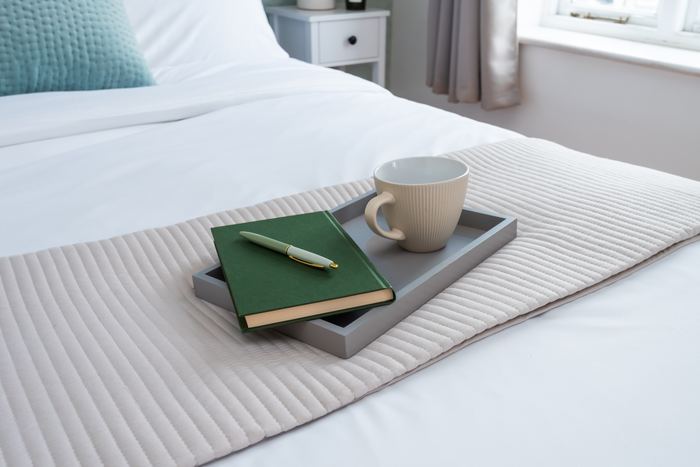 Bed tray home organising detail with a notebook, pen and mug