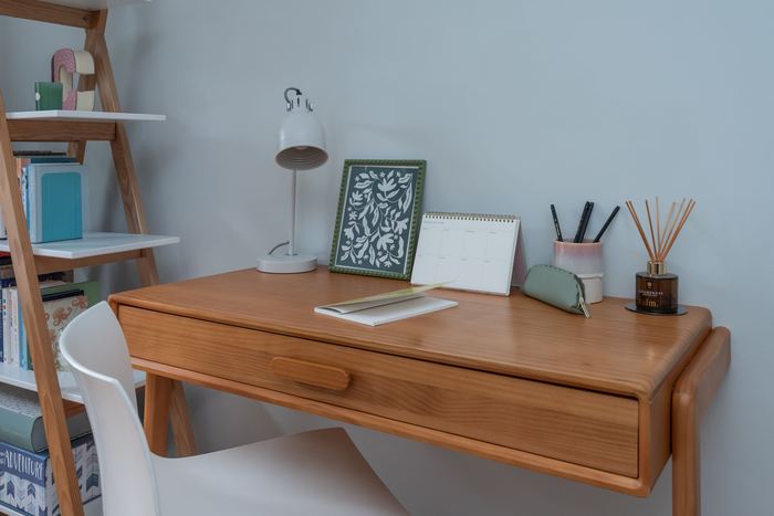 Desk styling vignette with a lamp, framed art and calendar