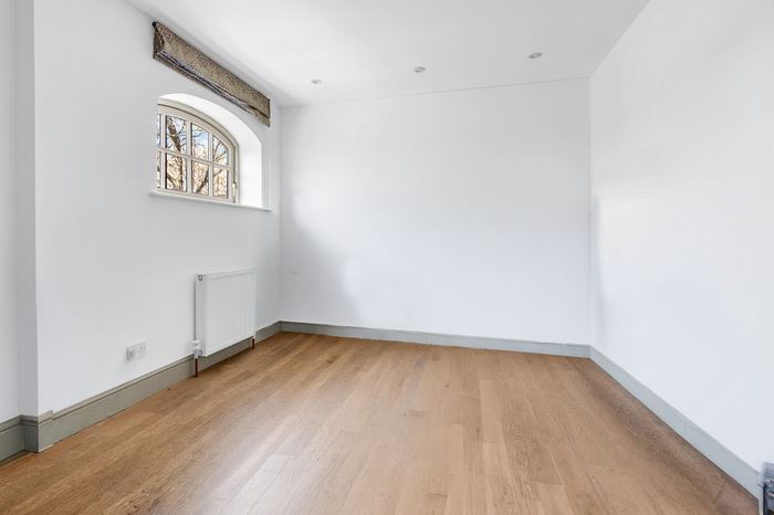 Empty bedroom before home staging, arched window