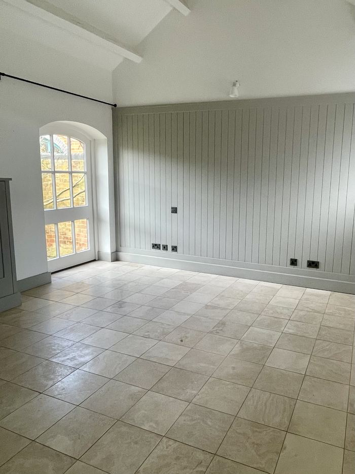 Empty room before home staging, tiled flooring and arched window